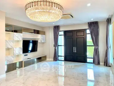 Luxurious living room with elegant chandelier and modern entertainment center
