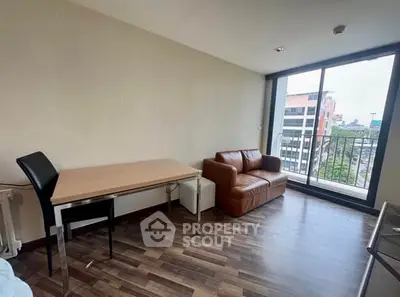 Modern living room with city view, featuring a cozy leather sofa and sleek dining table.