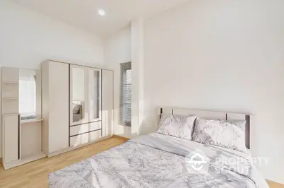 Spacious bedroom with large bed, ample natural light, and modern built-in wardrobes, perfect for urban living.