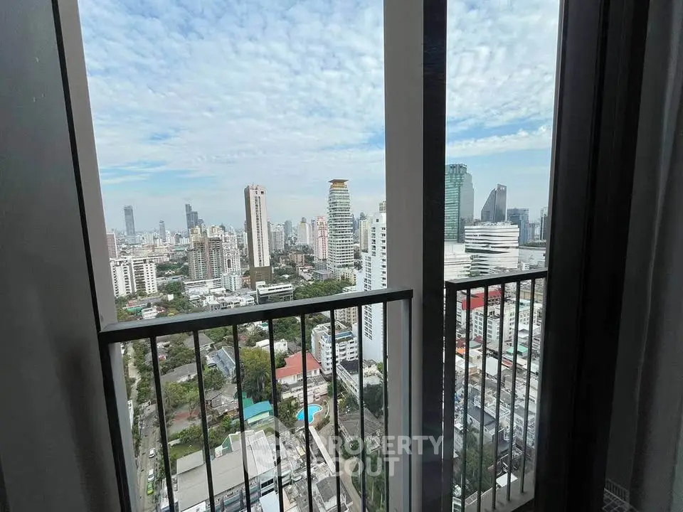 Stunning high-rise city view from a modern apartment balcony.