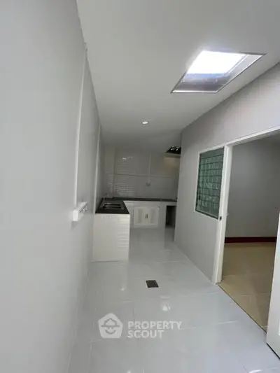 Modern kitchen with sleek white tiles and ample natural light