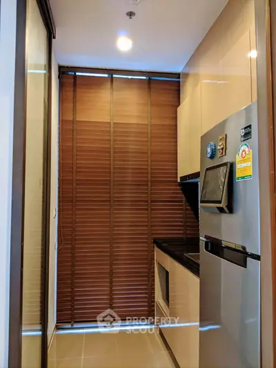 Modern kitchen with sleek appliances and stylish cabinetry in a compact layout.