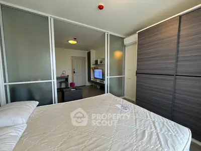 Modern bedroom with sliding glass doors and stylish wardrobe in a contemporary apartment.