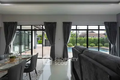 Spacious living room with pool view and elegant dining area in modern home