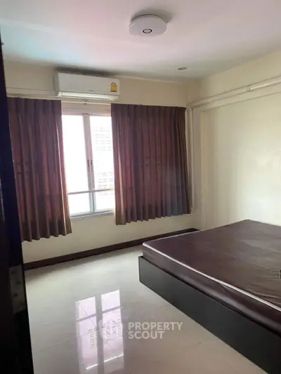 Spacious bedroom with large window and modern air conditioning unit