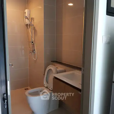 Modern bathroom with sleek fixtures and neutral tiles in a contemporary apartment.