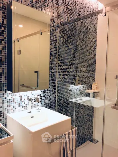 Modern bathroom with mosaic tiles and glass shower enclosure