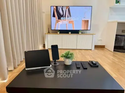 Modern living room with sleek furniture and large TV, showcasing a stylish and inviting atmosphere.