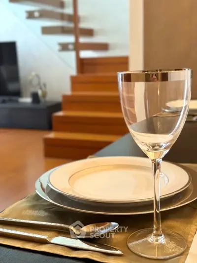 Elegant dining setup in modern living room with stylish staircase.