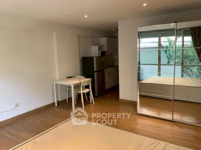 Spacious studio apartment with mirrored wardrobe and modern kitchen appliances.