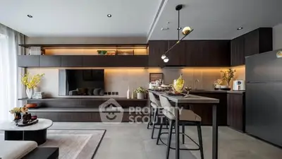 Modern kitchen with open layout and stylish dining area, featuring sleek cabinetry and contemporary lighting.