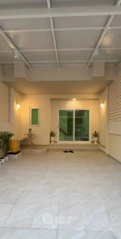 Spacious covered parking area with modern lighting and sliding glass doors.