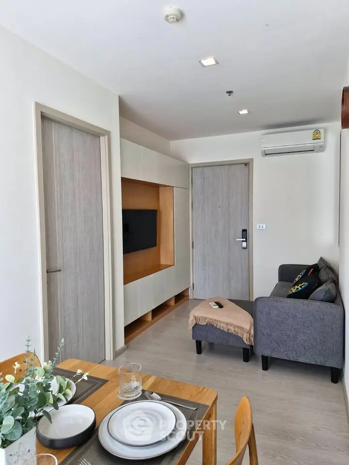 Modern living room with sleek furniture and dining area in a stylish apartment.