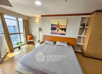 Spacious bedroom with city view and modern decor in high-rise apartment