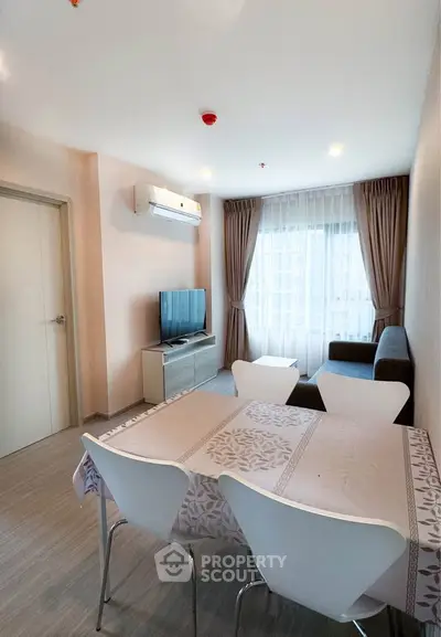 Modern living room with dining area, TV, and large window with curtains.