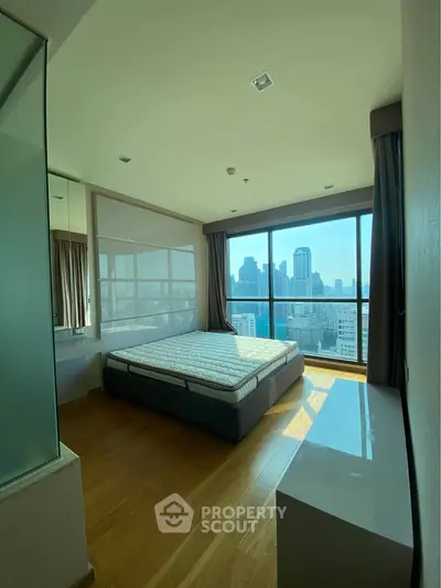 Spacious bedroom with city view and large windows in modern apartment