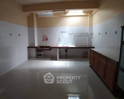Spacious kitchen with sleek countertops and ample storage in modern real estate property.