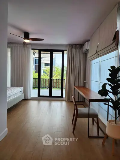 Spacious modern living room with large windows and wooden flooring