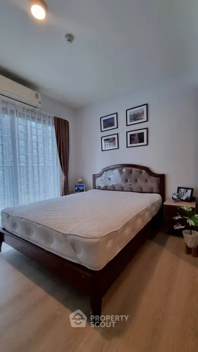 Spacious bedroom with elegant decor and large window for natural light