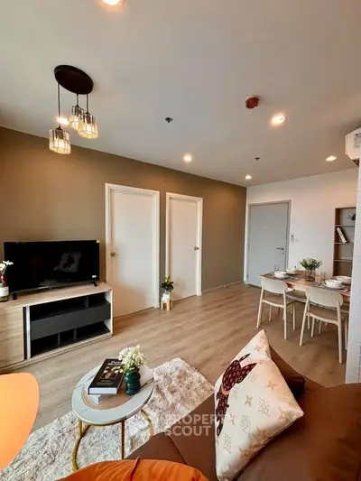 Modern living room with stylish decor and dining area in open layout apartment.