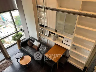 Modern loft apartment with high ceilings, large windows, and stylish furniture in urban setting.