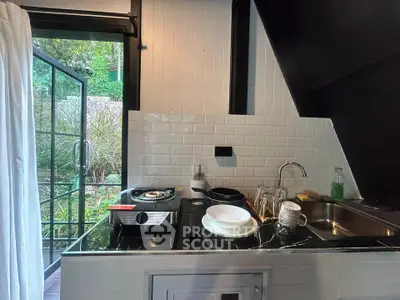 Charming kitchen with open layout and garden view, featuring modern appliances and sleek design.