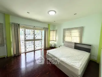 Spacious bedroom with large windows and wooden flooring, perfect for natural light lovers.