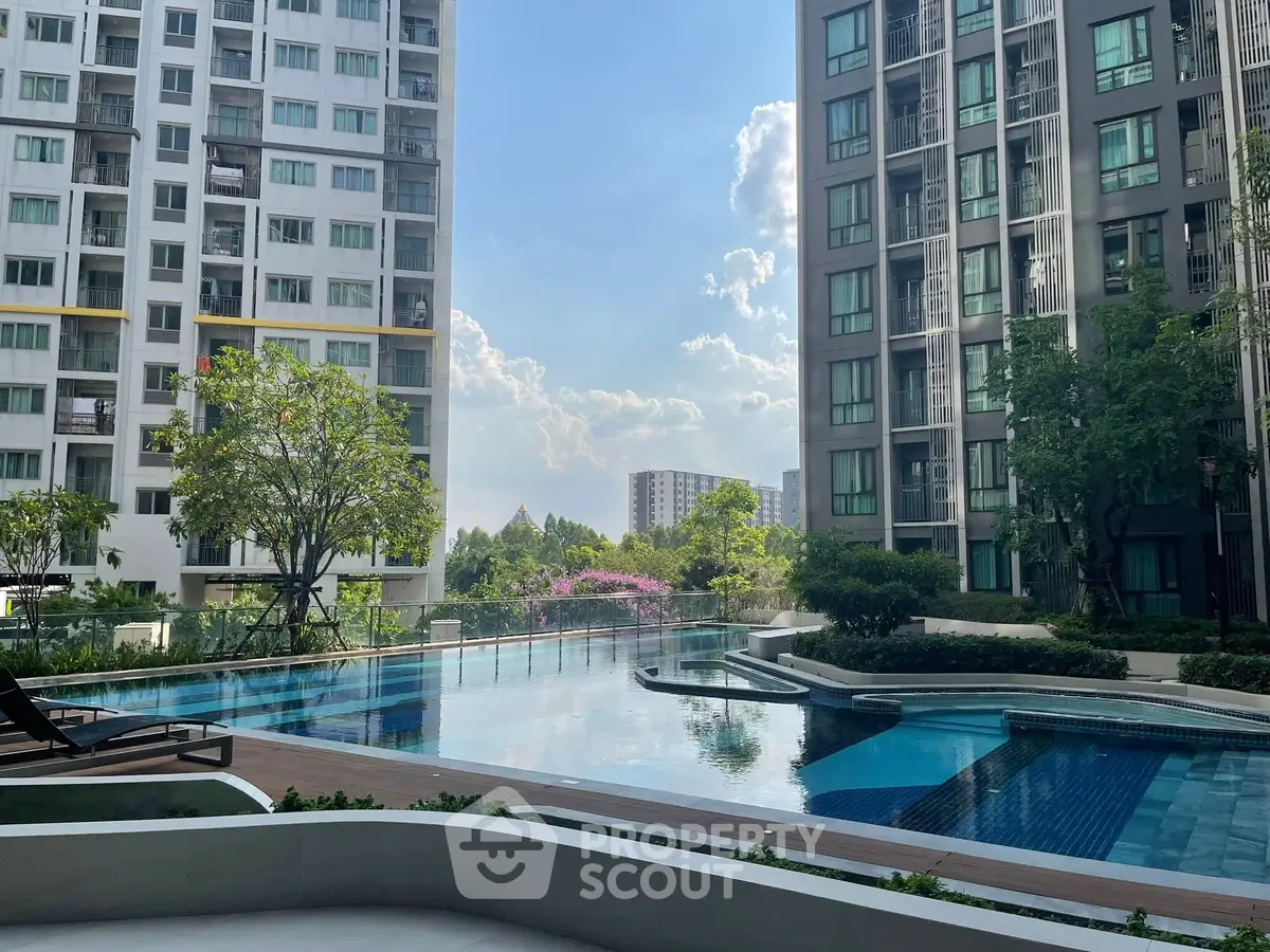 Luxurious residential complex with stunning pool and lush greenery, offering a serene urban oasis.