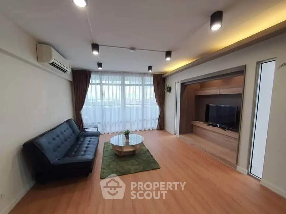 Spacious modern living room with sleek furniture and large windows offering natural light.