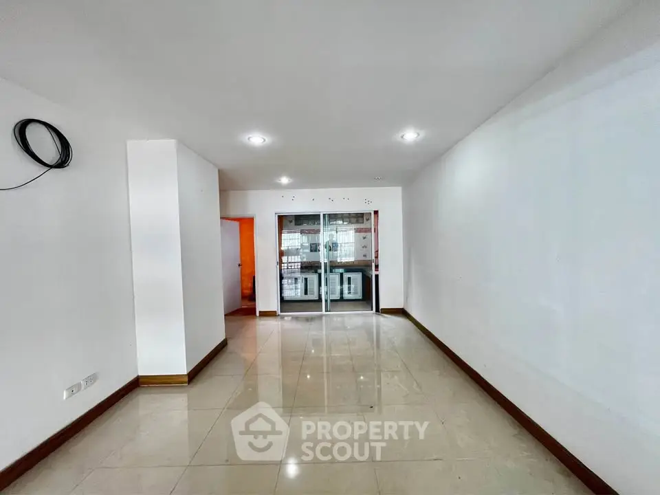 Spacious unfurnished living room with large windows and tiled flooring