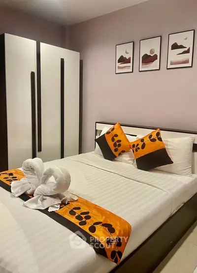 Cozy bedroom with modern decor and stylish bedding in a real estate property.