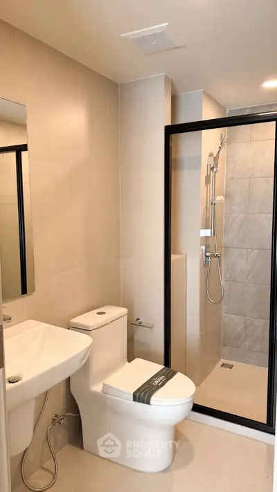 Modern bathroom with sleek shower and elegant fixtures in a contemporary apartment.
