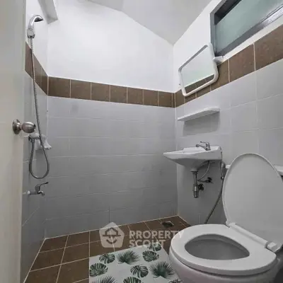 Modern bathroom with sleek fixtures and tiled walls, featuring a shower and toilet.