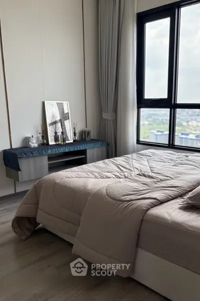 Modern bedroom with large window and stylish decor, offering a serene and cozy atmosphere.