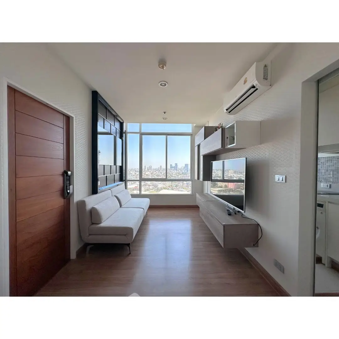 Modern living room with city view, sleek furniture, and large windows.