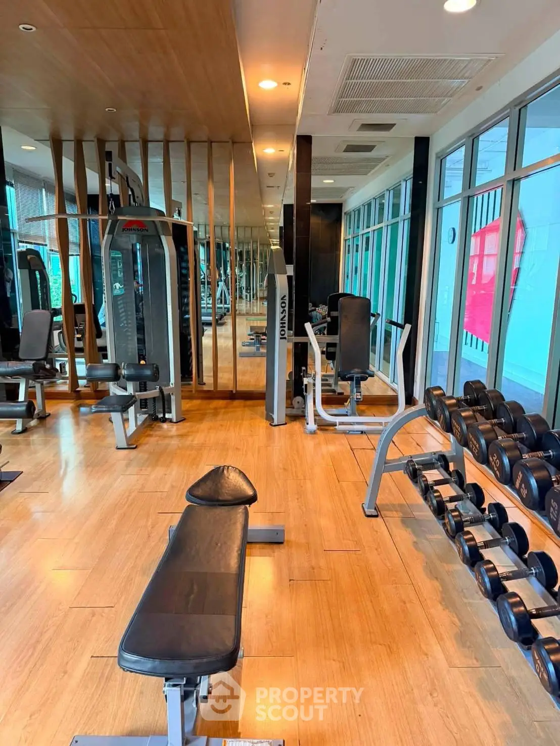 Modern gym with state-of-the-art equipment and mirrored walls in a luxury residential building.