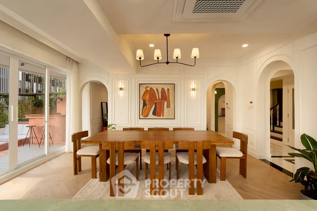 Elegant dining room with wooden table and modern chandelier in a stylish home.