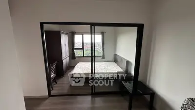 Modern bedroom with large window and mirrored sliding doors, offering a bright and spacious feel.