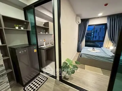 Modern studio apartment with compact kitchen and cozy bedroom, ideal for urban living.