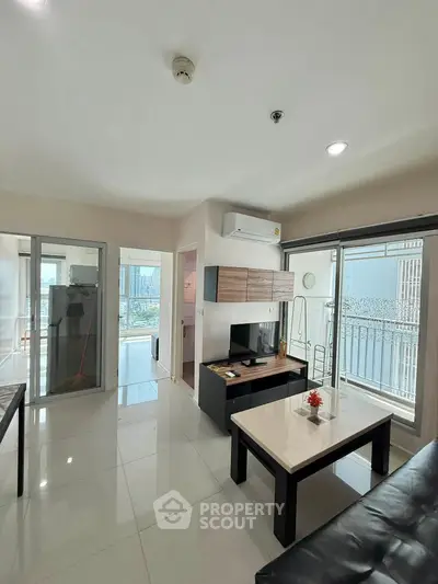 Modern living room with sleek furniture and balcony view in a stylish apartment.