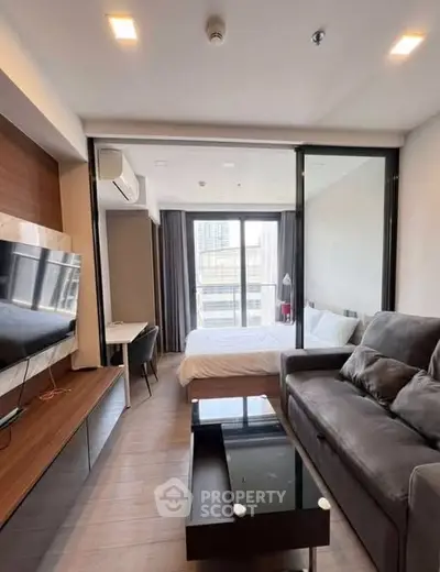 Modern studio apartment with sleek design and city view, featuring a cozy living area and stylish bedroom.