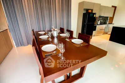 Elegant dining area with modern wooden table and sleek kitchen appliances