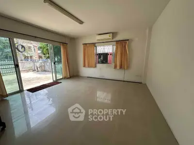 Spacious unfurnished room with large windows and garden view