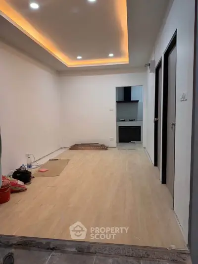 Modern interior with recessed lighting and open layout leading to a compact kitchen.