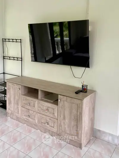 Modern living room with sleek TV setup and stylish wooden cabinet, perfect for contemporary home entertainment.