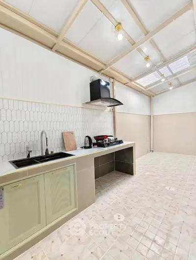 Spacious kitchen with modern design and ample natural light, featuring sleek countertops and stylish backsplash.