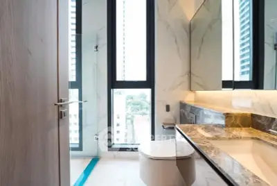 Luxurious modern bathroom with marble finishes and large windows in high-rise apartment.