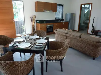 Modern open-plan living room with dining area and stylish kitchen appliances.