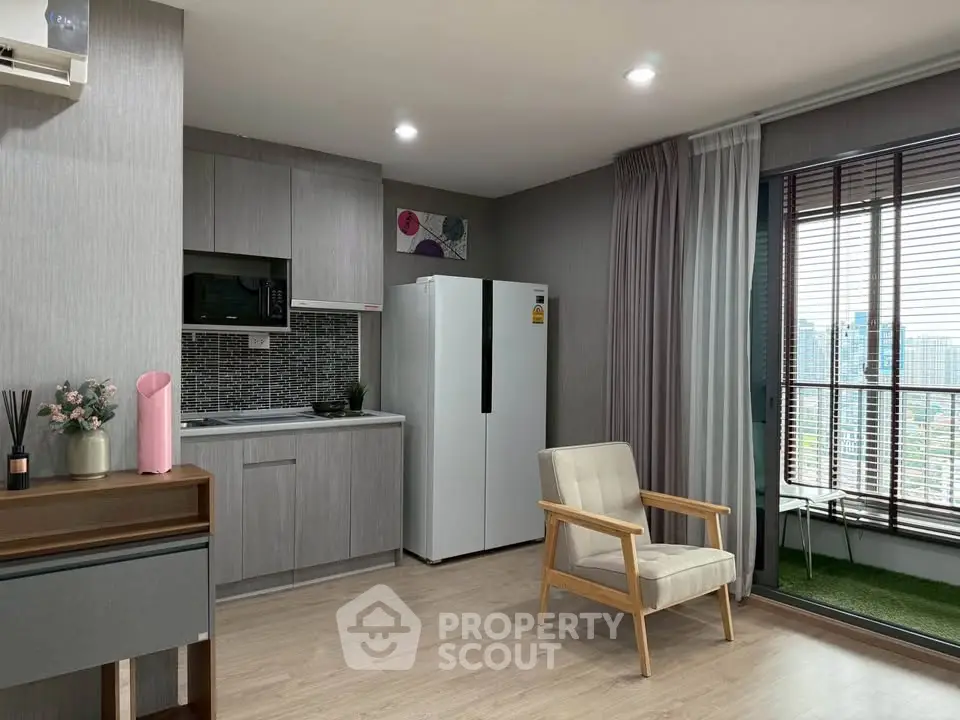 Modern open-layout kitchen with sleek appliances and cozy seating area, featuring a large window with city view.