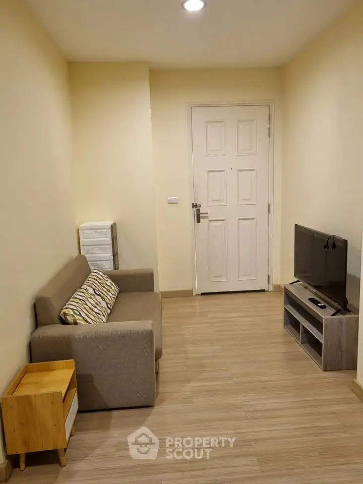 Cozy living room with modern sofa and TV setup, perfect for relaxation.